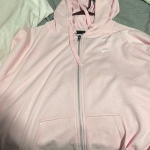 It’s a Nike baby pink zip up sweater with two slits on side and it does not fit